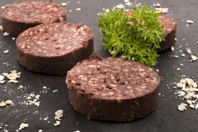 slice of black pudding on black background