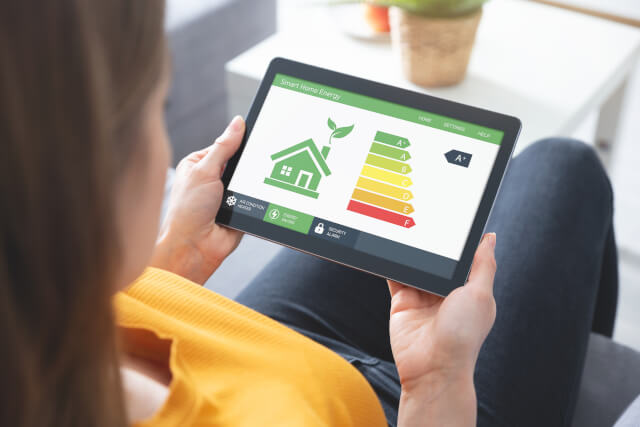 Energy efficiency mobile app on screen, eco house