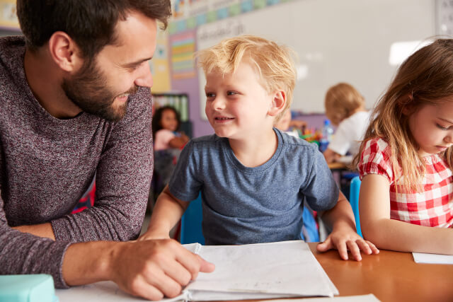 Male Teacher and Boy Pupil Smiling