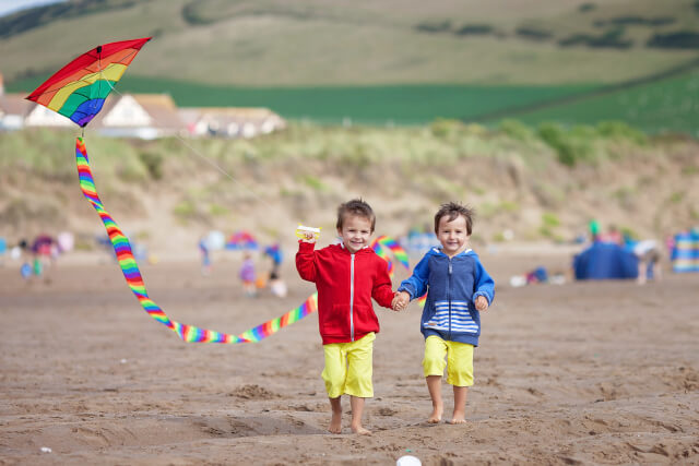 Two children flying a kite on the beach
