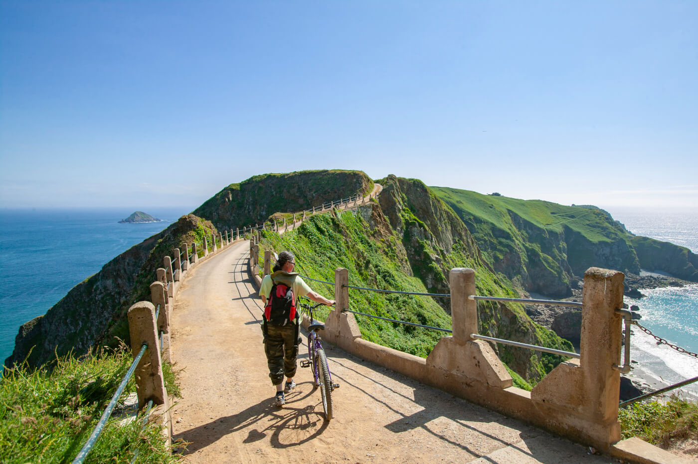 Woman cycling on coastal path