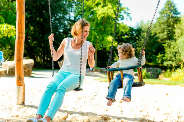 Mother and toddler on swings at a dog-friendly wall in Gloucestershire 