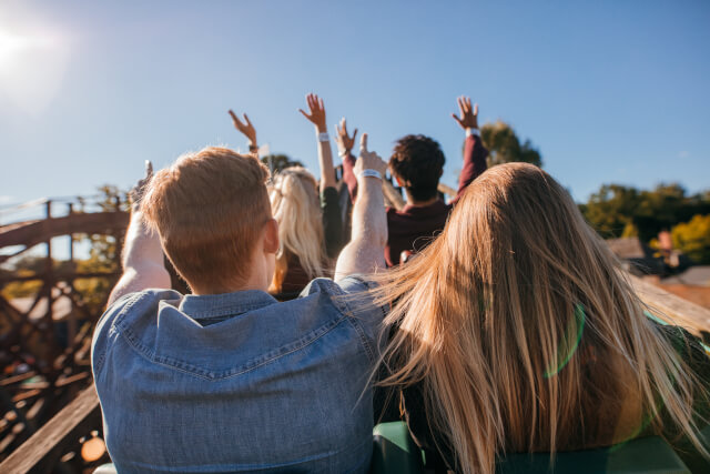 group of adults going up a roller coaster