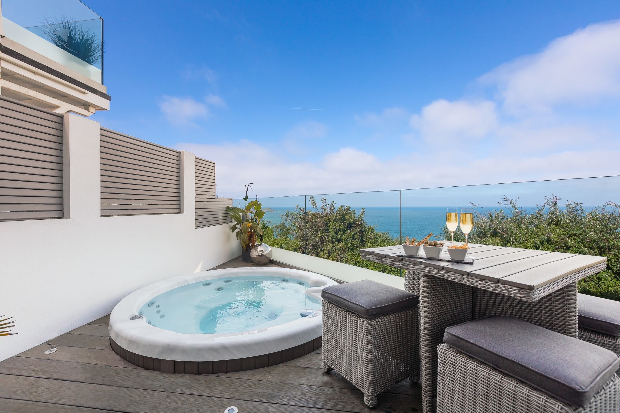 Hot tub on decking with balcony looking towards the sea