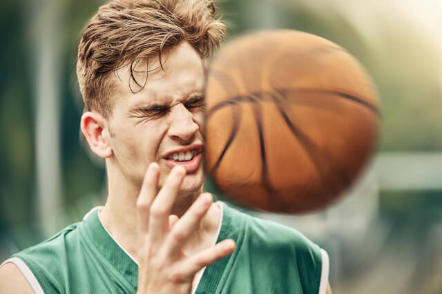 man being hit in face by basketball