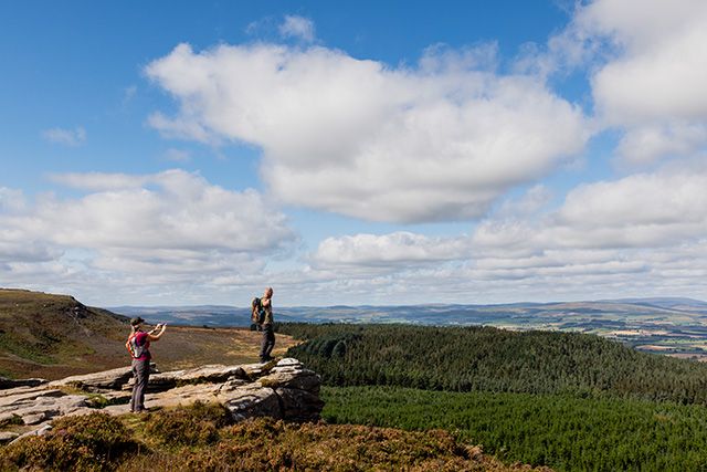 People looking across Simonside hills wal