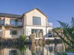 Exterior shot of Swallows Dip and a pond in the garden.