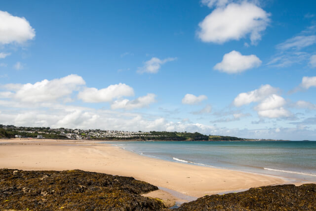 Benllech Beach from the south-east, with the headland and a holiday park visible at the far end of the beach 