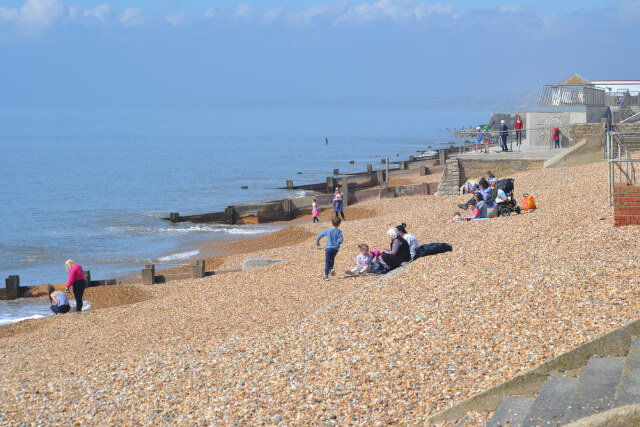 An images of families on the shore of Milford on Sea Beach in Hampshire