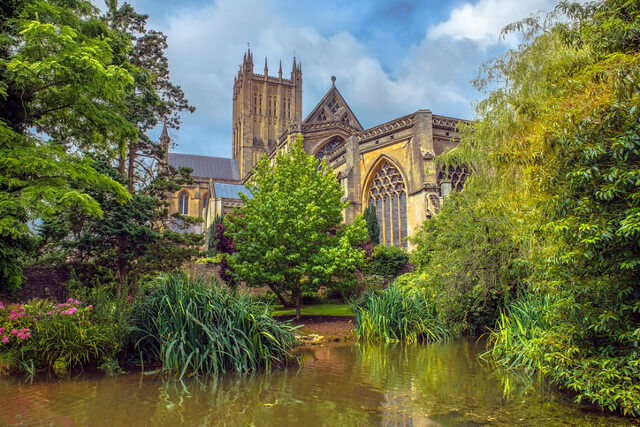 Looking up at the front and main tower of Wells Cathedral from The Garden of Reflection in Wells, Somerset