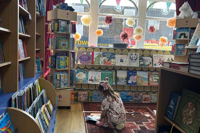 Child reading in The Edge of the World Book Shop in Penzance