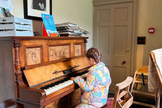 Poppy playing the piano at Allan Bank in Grasmere