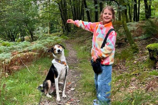 Photo of a young girl and her dog on a walk