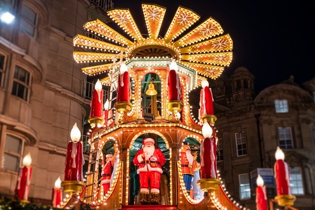 Traditional Christmas market carousel with lights and Santa display in Birmingham.