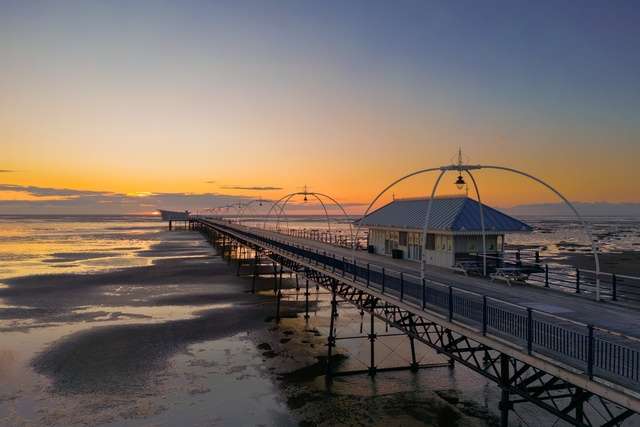 Sunset over Southport pier and water.
