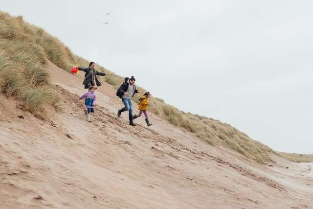 family running down sandune