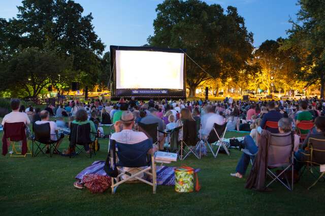 People watching a film at an outdoor cinema