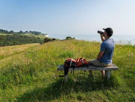 A man sat on bench overlooking White Cliffs of Dover