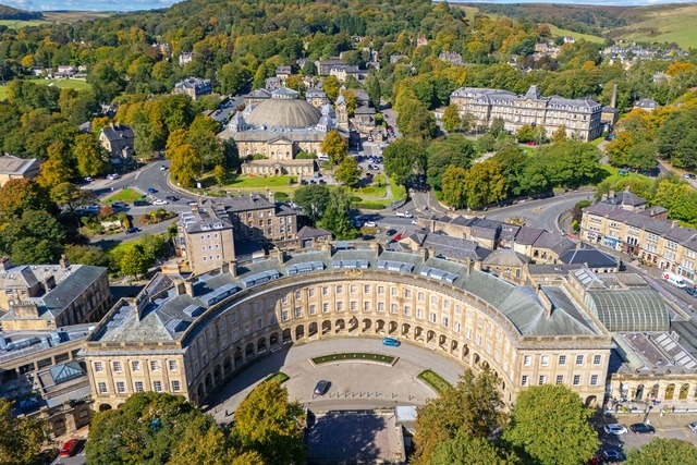 Aerial view of Buxton town centre with the Crescent and surrounding Peak District countryside.