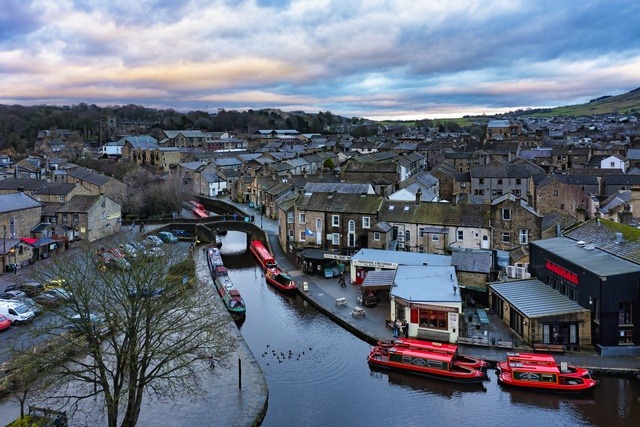 View of Skipton canal with narrowboats and stone buildings in the Yorkshire market town.