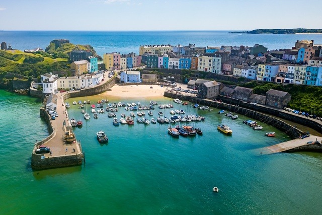 Aerial view of Tenby harbour with colourful seaside houses and boats in Pembrokeshire.