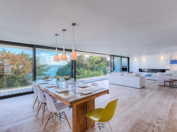 Open-plan living space at Salt House with patio doors looking out to the coast.