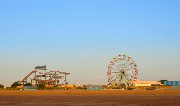 Skegness, England - June 8, 2015: Skegness beach, the big wheel and the fair ground, early morning, in June. In Skegness, Lincolnshire, England.