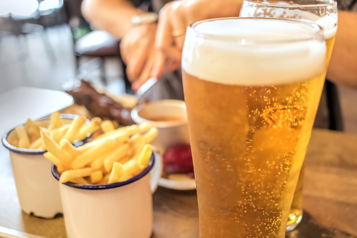 Restaurant dining, beer and barbecue food is available at several resturaunts Devon, Exmouth | Image of a Pint of lager with two portions of chips in white ceramic ramekins