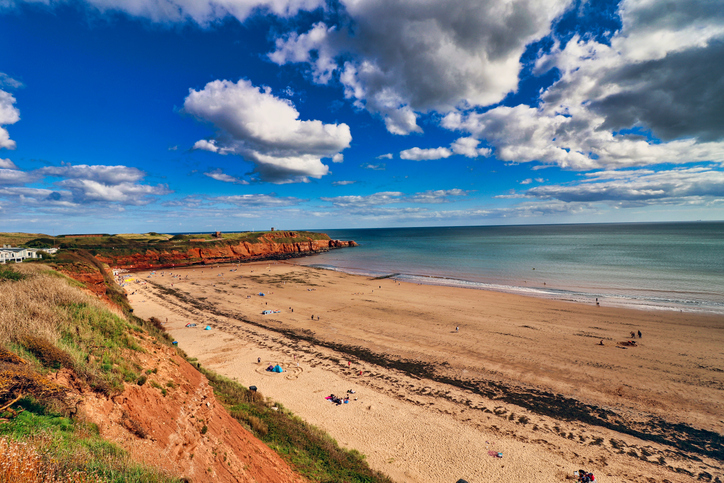 A landscape photograph of Sandy Bay Beach at Exmouth, Devon, UK