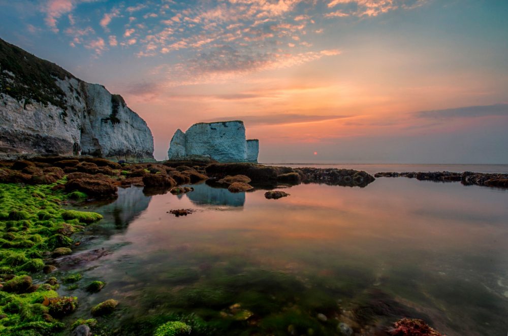 Sun rising behind Old Harry Rocks, the most easterly point of the Jurassic Coast