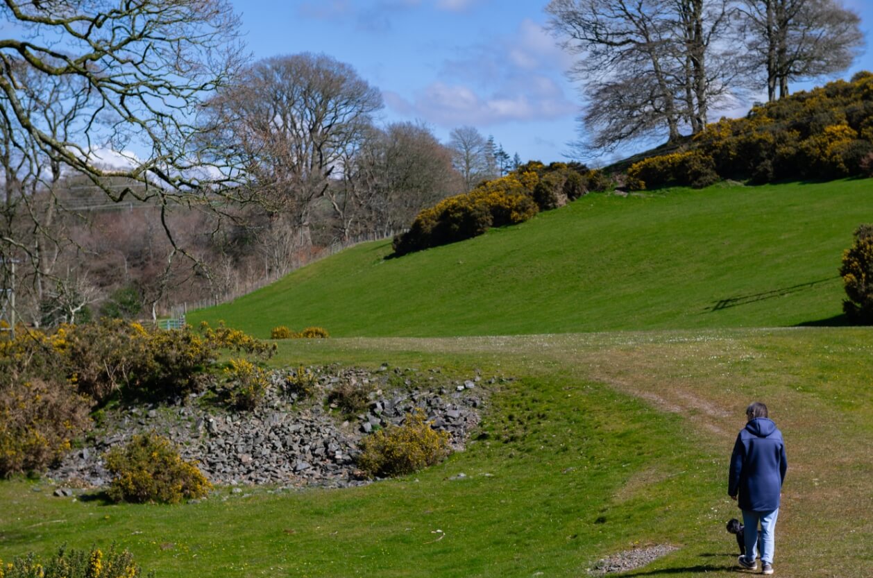 Mature woman walking her dog in a rural location