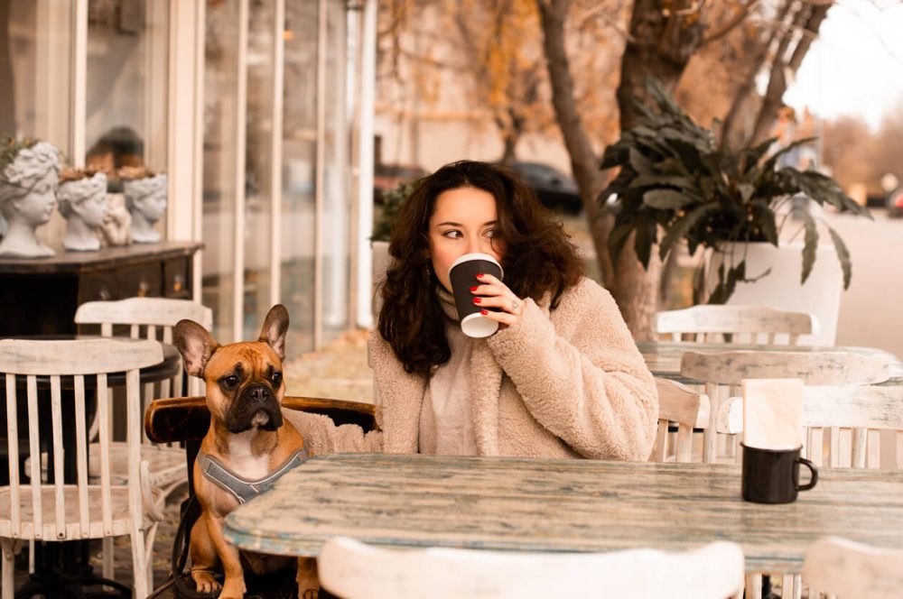 woman drinkinf coffee outside with dog