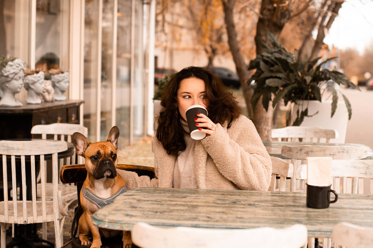 woman drinkinf coffee outside with dog