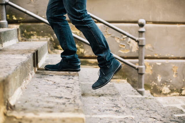 Close up of man walking up steps