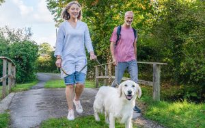 Couple walking a dog in the countryside