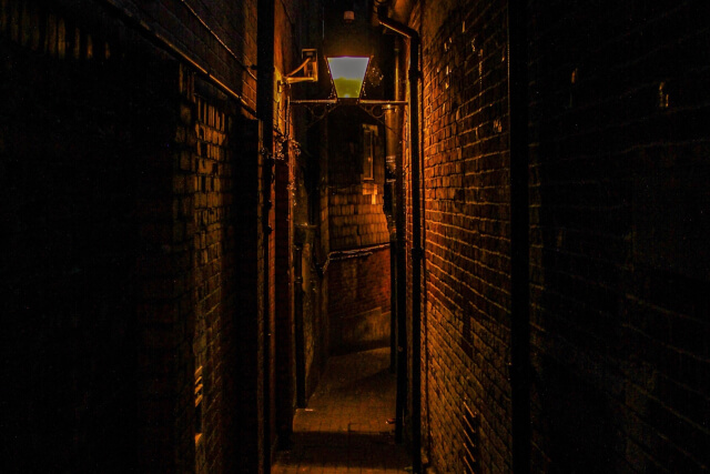 Dark alleyway at night with gas lamp