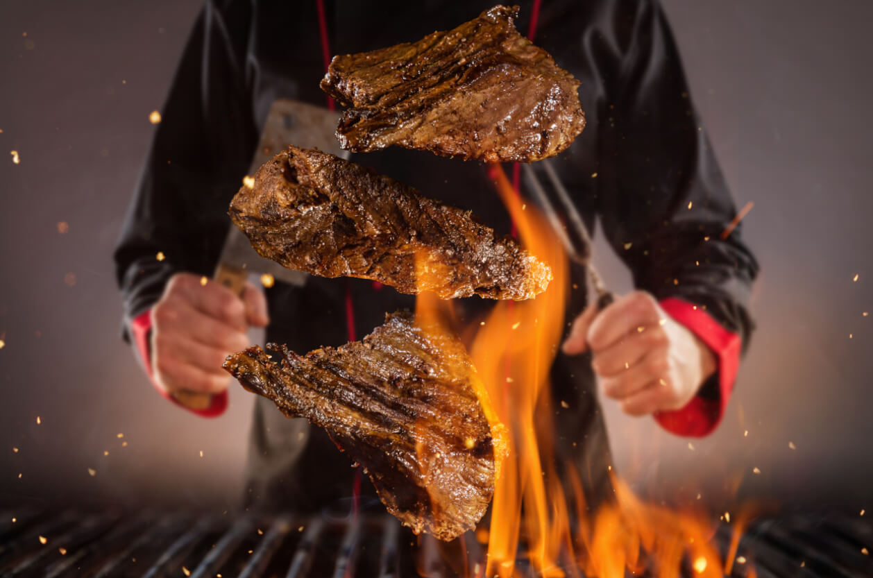 chef cooking steak on barbecue grill