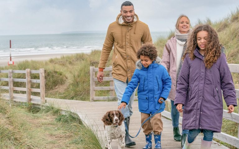 Family of four walking their dog on the dunes boardwalk
