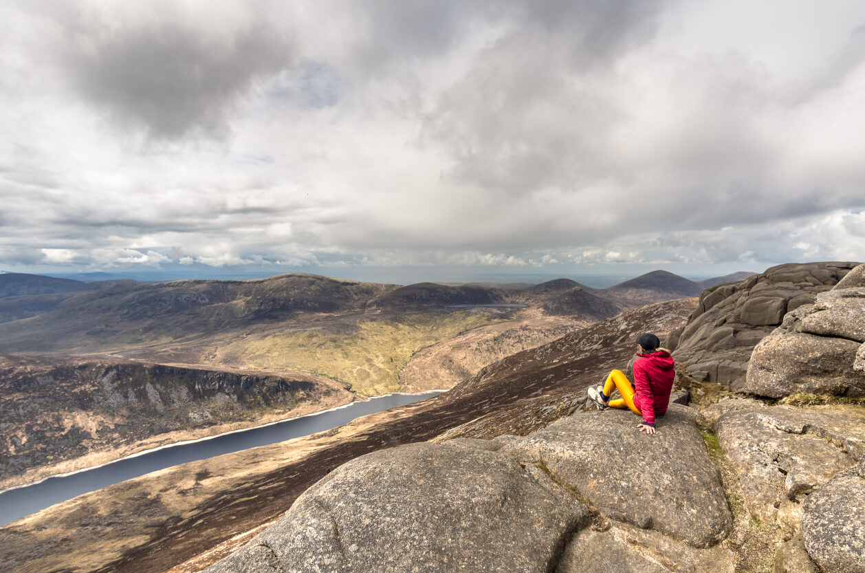 Hiker sat on rocky mountain