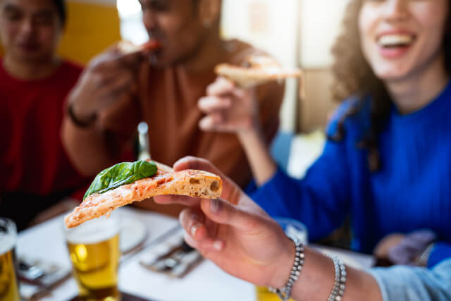 Friends eating pizza in restaurant