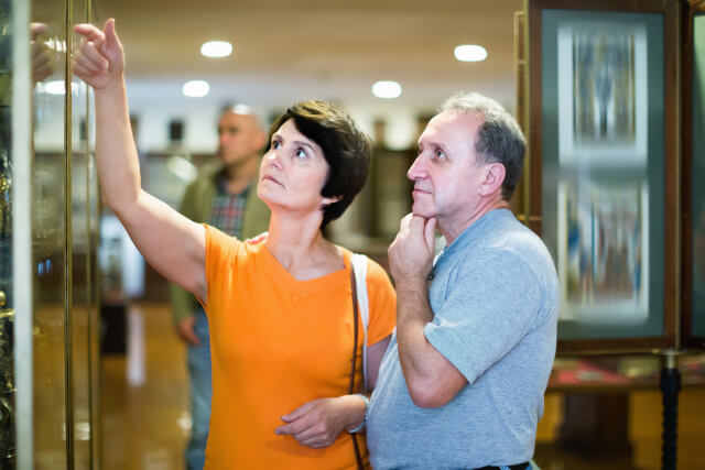 Man and woman viewing exhibits in museum