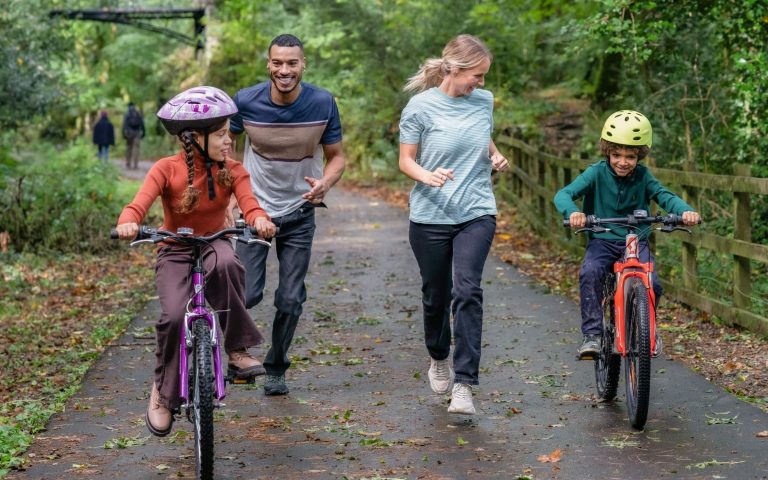 Parents walking with their children on bikes