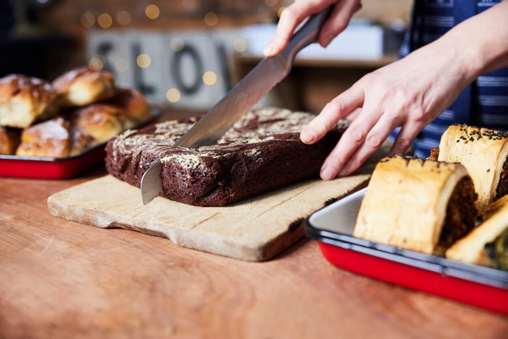 Sales Assistant In Bakery Cutting Freshly Baked Baked Brownies