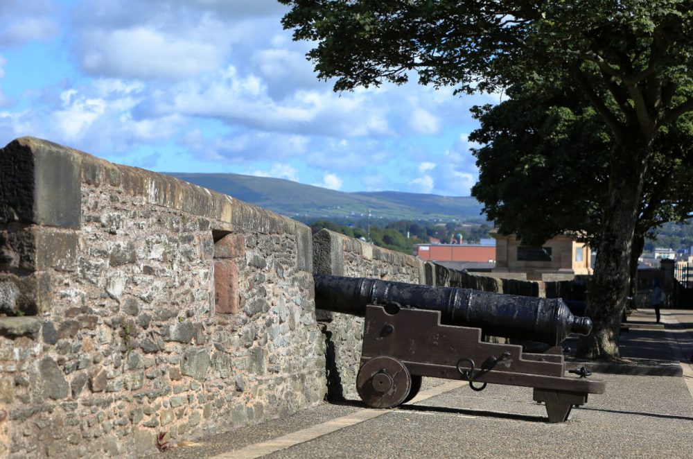 Side view of Derry Walls defence with hills in distance
