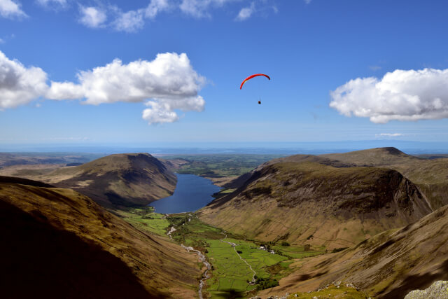 a person paragliding over the lake district