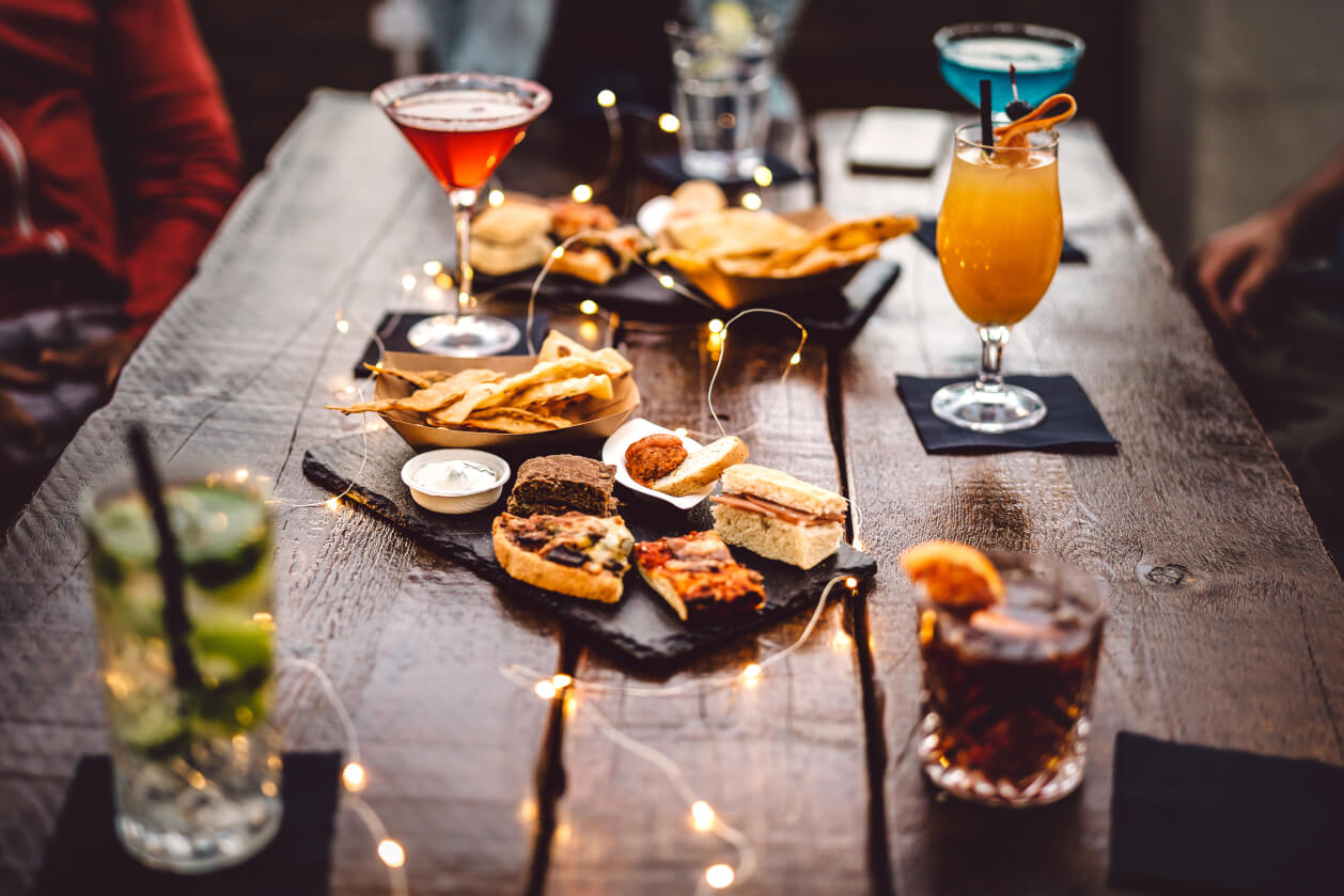 a selection of food with cocktails and led lights