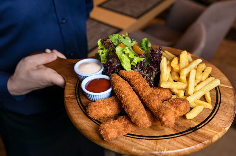 chicken strips with chips on a board