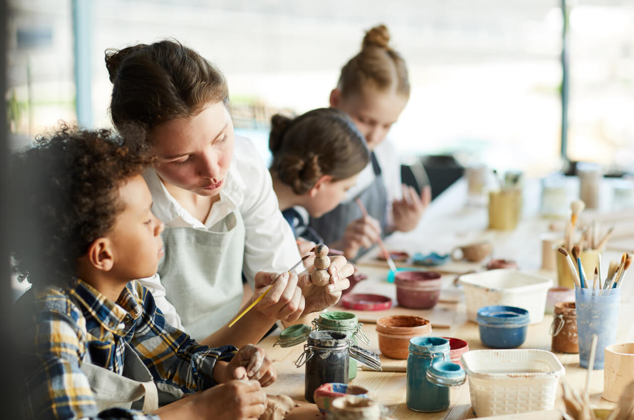 children and lady at pottery workshop