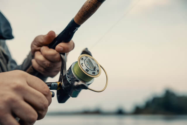 close up of hand using fishing rod