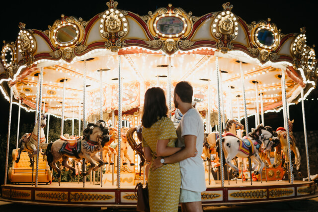 couple embracing in front of fairground